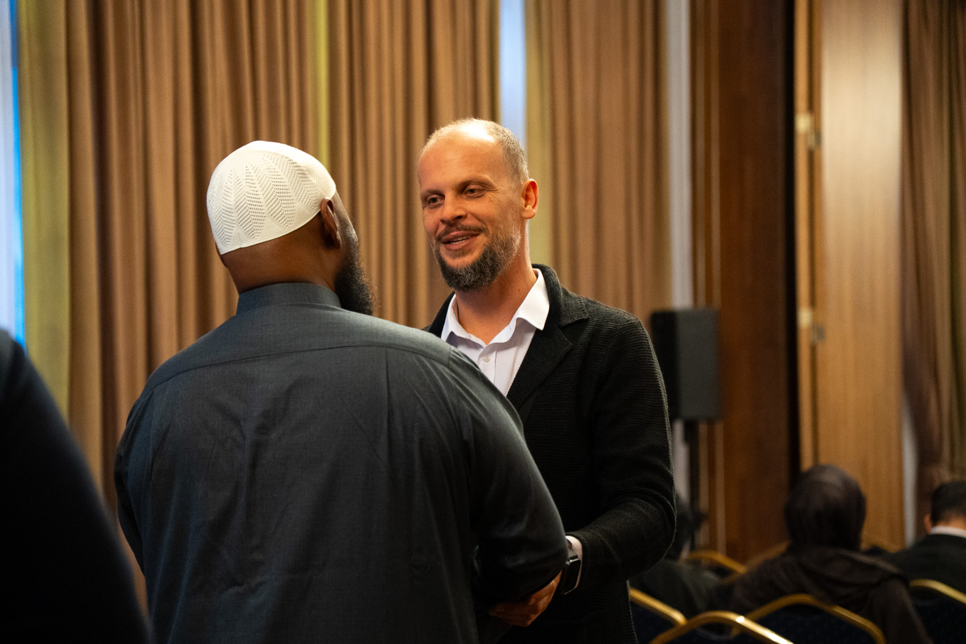 Hassan speaking personally with a guest at the Bosnia destination event